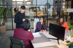 The Wilby Jones team collaborating in a modern office meeting space, discussing financial strategies and client projects.